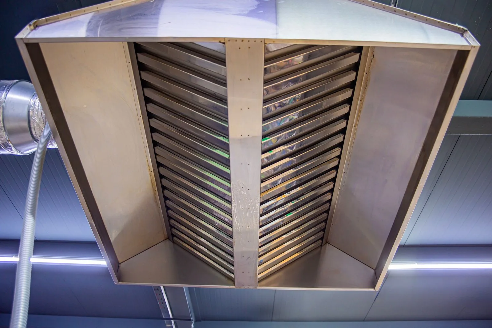 Grote RVS-afzuigkap met filters in een centrale keuken