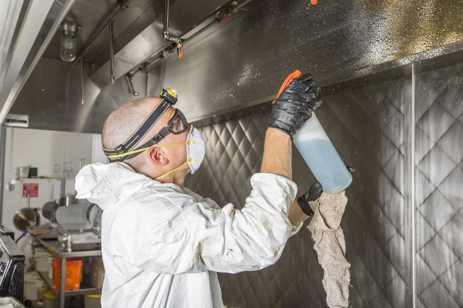 Monteur reinigt het vetkanaal in een professionele keuken