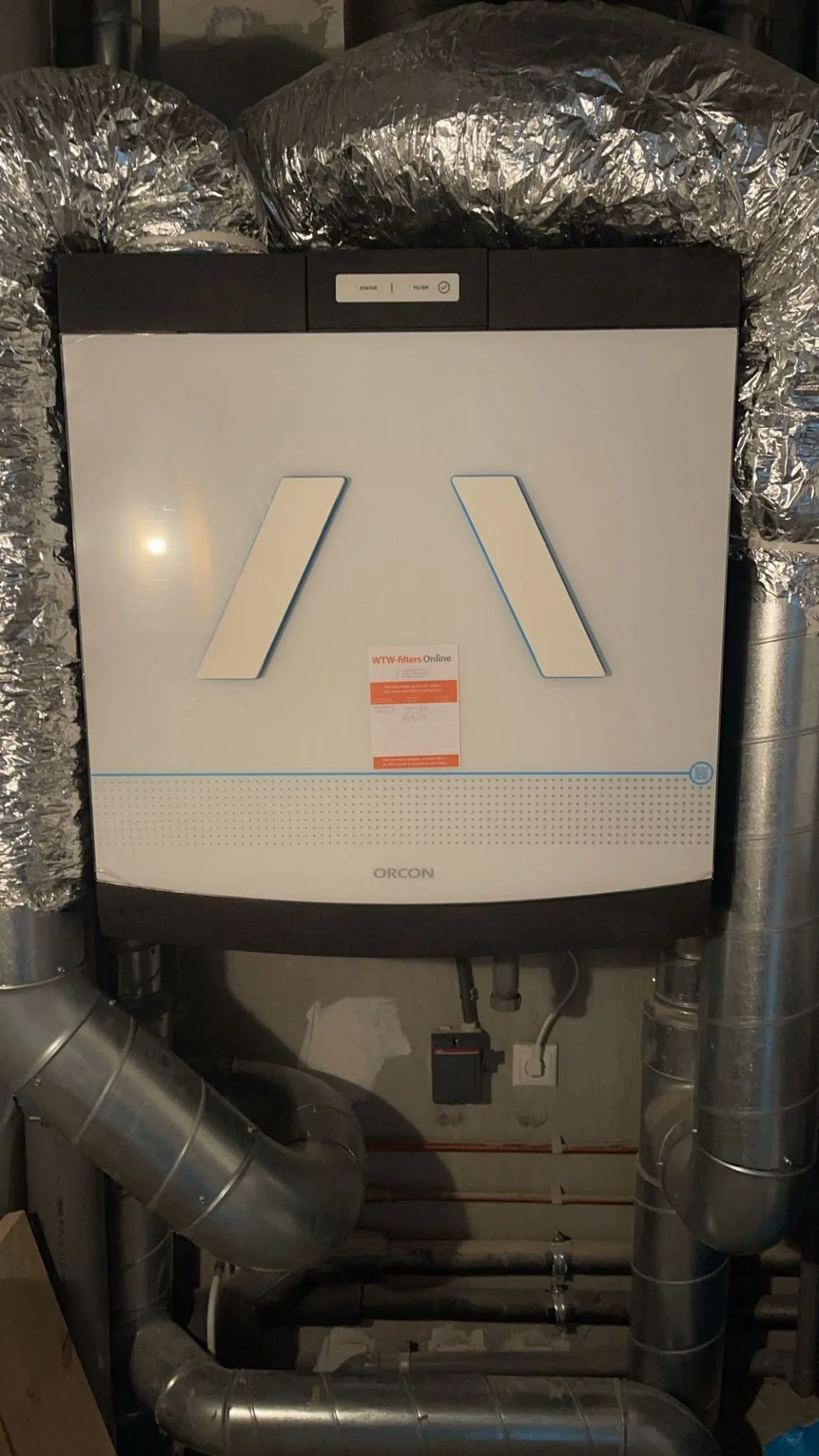 WTW-unit van Orcon met aangesloten luchtkanalen in een technische ruimte
